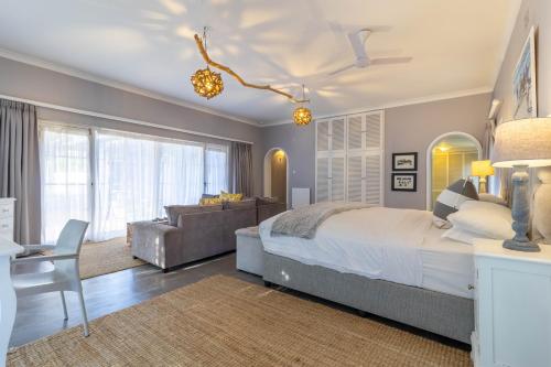 a bedroom with a large bed and a couch at Whale Rock Luxury Lodge in Hermanus