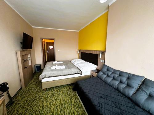 a hotel room with a bed and a couch at Hotel Opera in Jaroměřice na Rokytné