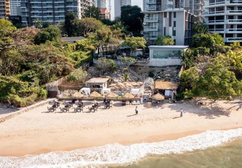 an aerial view of a beach with chairs and tables at Golden Tulip Pattaya Beachfront Resort in Pattaya North