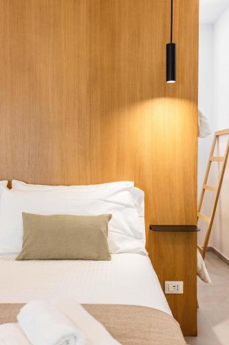 a bedroom with a bed with a wooden headboard at Capo D'Amuri in Palermo