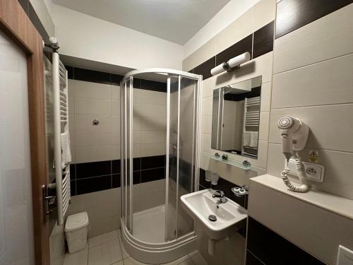 a bathroom with a shower and a sink at Hotel Opera in Jaroměřice na Rokytné