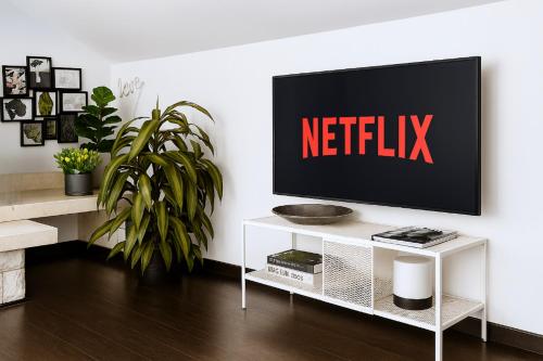 Un televisor sobre un soporte blanco con un cartel de Netflix. en Borgo d'Oro Loft, en Bérgamo