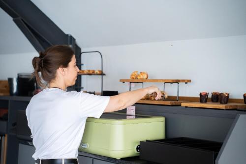 a woman is preparing food in a kitchen at Smartr Porto Gaia in Vila Nova de Gaia