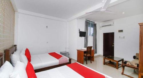 a bedroom with two beds and a ceiling fan at New Kings Gate Airport Transit Hotel in Katunayake