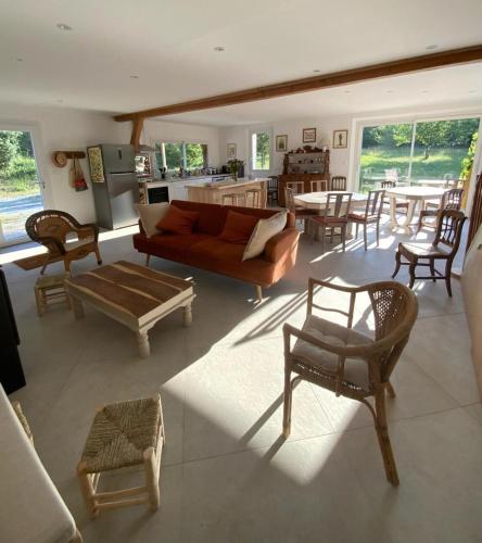 a living room with a couch and a table and chairs at En joia ! in Teyssode