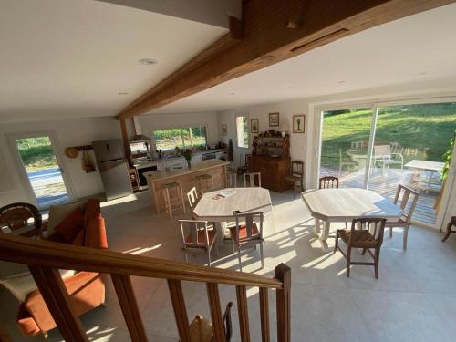a living room with tables and chairs and a kitchen at En joia ! in Teyssode
