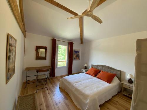 a bedroom with a bed with orange pillows on it at En joia ! in Teyssode