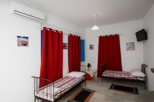 a room with two beds and red curtains at Santo Margarita in Oia