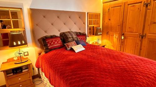 a bedroom with a large bed with a red comforter at Cozy Gstaad Chalet With Modern Touch in Gstaad