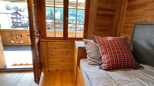 a room with a bed in a cabin with windows at Cozy Gstaad Chalet With Modern Touch in Gstaad