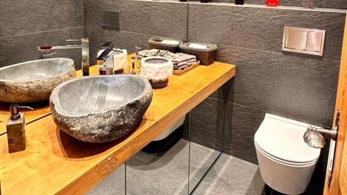 a bathroom with two sinks on a wooden counter at Cozy Gstaad Chalet With Modern Touch in Gstaad