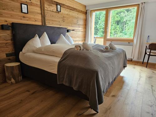 a large bed in a room with wooden walls at Typically Swiss Hotel Ermitage in Kandersteg