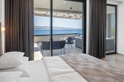 a bedroom with a bed and a view of the ocean at NEW! Villa Angelus – Your Luxurious Retreat near the Sea in Omiš