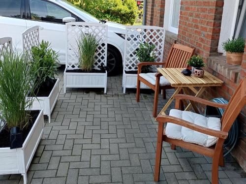 a patio with chairs and a table and potted plants at Gemütliche Ferienwohnung 