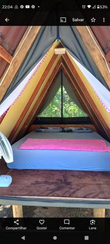 a bed in a tent with a window at Cabana 2 Camping Dona Aurora Praia do Sono in Paraty