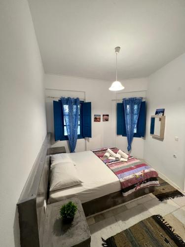 a bed in a room with blue windows at Santo Margarita in Oia