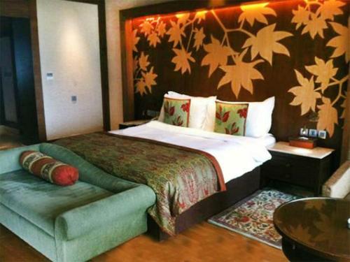 a bedroom with a bed and a couch in it at The LaLit Grand Palace Srinagar in Srinagar