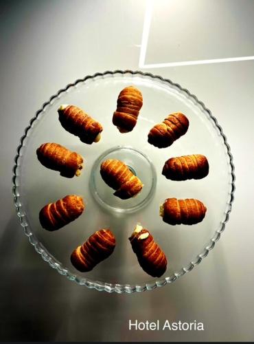 a plate of food with croissants on a table at Hotel Astoria in Torri del Benaco