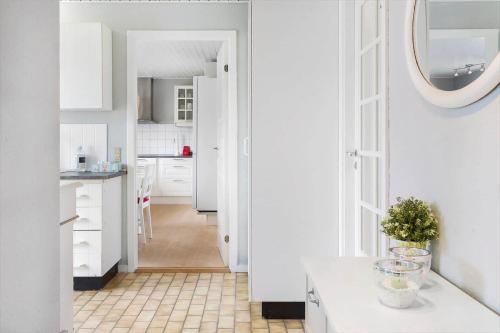 a kitchen with white cabinets and a table in a room at 110-Vestervig-Svanholmvej-10 in Vestervig