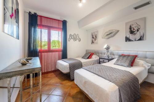 a hotel room with two beds and a table at Tranquil Haven in Ibiza City, 1254 in Sant Francesc de s'Estany