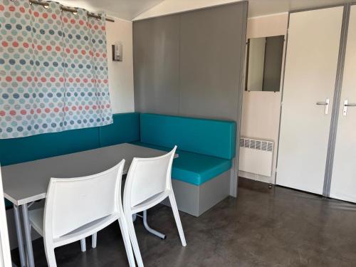 a dining room with a blue bench and white chairs at Solmeco Park in Aldeia do Meco