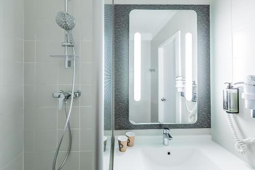 a bathroom with a shower and a mirror at Hotel ibis Evora in Évora