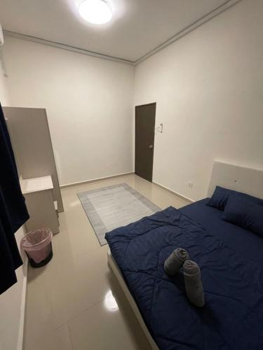 a bedroom with a blue bed with a pair of shoes on it at Kemaman KondoRoomStay SwimPool,Gym, Chukai Trg in Cukai