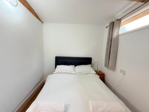a bed in a small room with a window at Oxford Guest House in Oxford