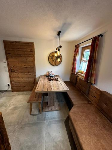 a living room with a wooden table and a couch at Haus Bergliebe in Winkl Reichenau