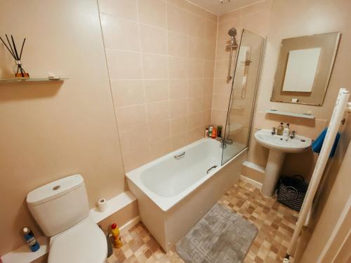 a bathroom with a tub and a toilet and a sink at Harbourside Apartment in Bristol in Bristol