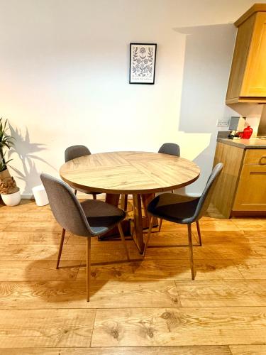 a wooden table and chairs in a kitchen at Harbourside Apartment in Bristol in Bristol
