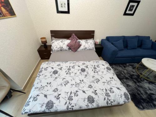 a bedroom with a bed and a blue couch at Cozy Studio with Sofa bed beside DMCC Metro & Dubai Marina in Dubai