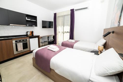 a hotel room with two beds and a kitchen at New Luxury 2 Single Bed Studio Apartment- BV3 in St Paul's Bay