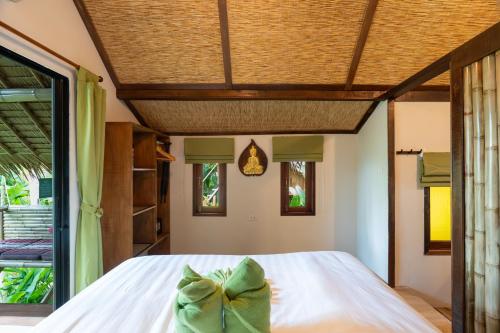 a bedroom with a bed with a bow on it at Bamboo Bay Eco Resort in Srithanu