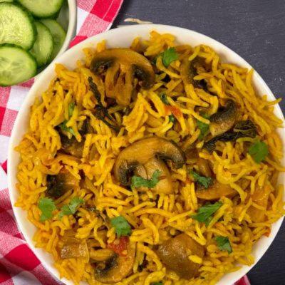 a bowl of food with noodles and mushrooms on a table at Dhanunjayas Luxury Hotel in Hosūr