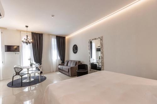 a bedroom with a bed and a table and a couch at Opera Relais De Charme - Aparthotel in Verona