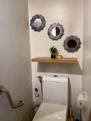 a bathroom with two mirrors above a toilet at The Monroe at Horizons 101 in Cebu City