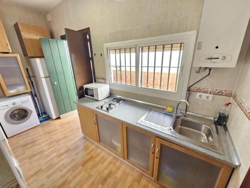 una piccola cucina con lavello e microonde di Apartamento centro a Chipiona