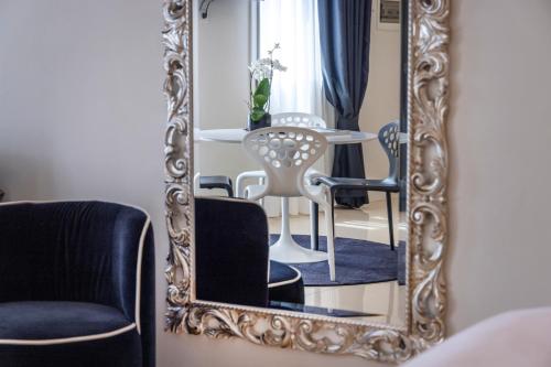 a mirror in a room with a table and chairs at Opera Relais De Charme - Aparthotel in Verona