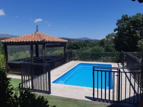 a swimming pool with a gazebo and a swimming pool at Casa Rural La Casita Roja in Burgohondo