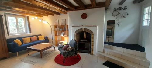 a living room with a couch and a fireplace at L'ancienne boulangerie du Grand Verger 7 pers in Déols