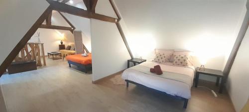 a bedroom with a bed and a chair in a room at L'ancienne boulangerie du Grand Verger 7 pers in Déols