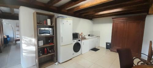 a kitchen with a washer and dryer in a room at L'ancienne boulangerie du Grand Verger 7 pers in Déols