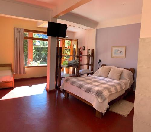 a bedroom with a bed and a television in it at El Portal del Lago in Lago Puelo
