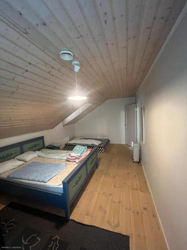 two beds in a room with a wooden ceiling at Lake house 56 km from Helsinki in Lohja