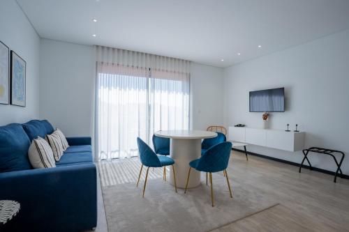 a living room with a blue couch and a table and chairs at Smartr Porto Gaia in Vila Nova de Gaia