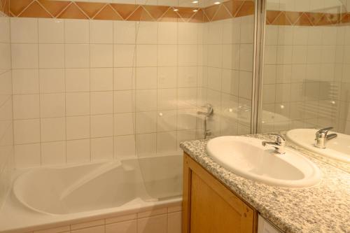 une salle de bain avec une baignoire et un lavabo et une baignoire dans l'établissement Le Névé, à Saint-Gervais-les-Bains