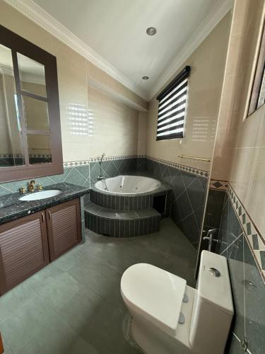 a bathroom with a toilet and a tub and a sink at Majestic Bungalow Seberang Jaya in Perai