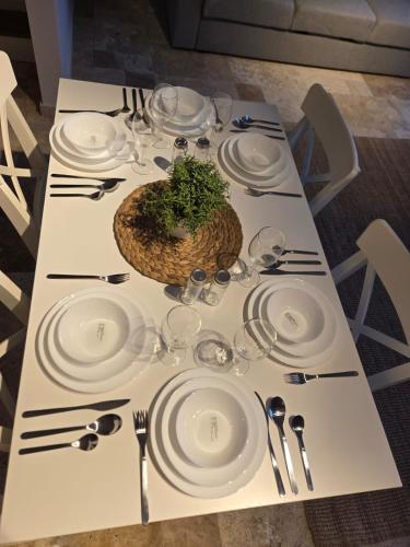 a table with white plates and a plant on it at Denize yakın dubleks tatil keyfi 1 in Kızılot