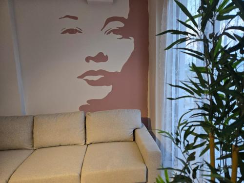 a living room with a couch and a painting of a man at Denize yakın dubleks tatil keyfi 1 in Kızılot
